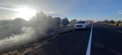 YCSO TAHOE ON SIDE OF ROADWAY WITH SMOKE FROM BRUSH FIRE CAUSED BY DRAGGING CHAINS